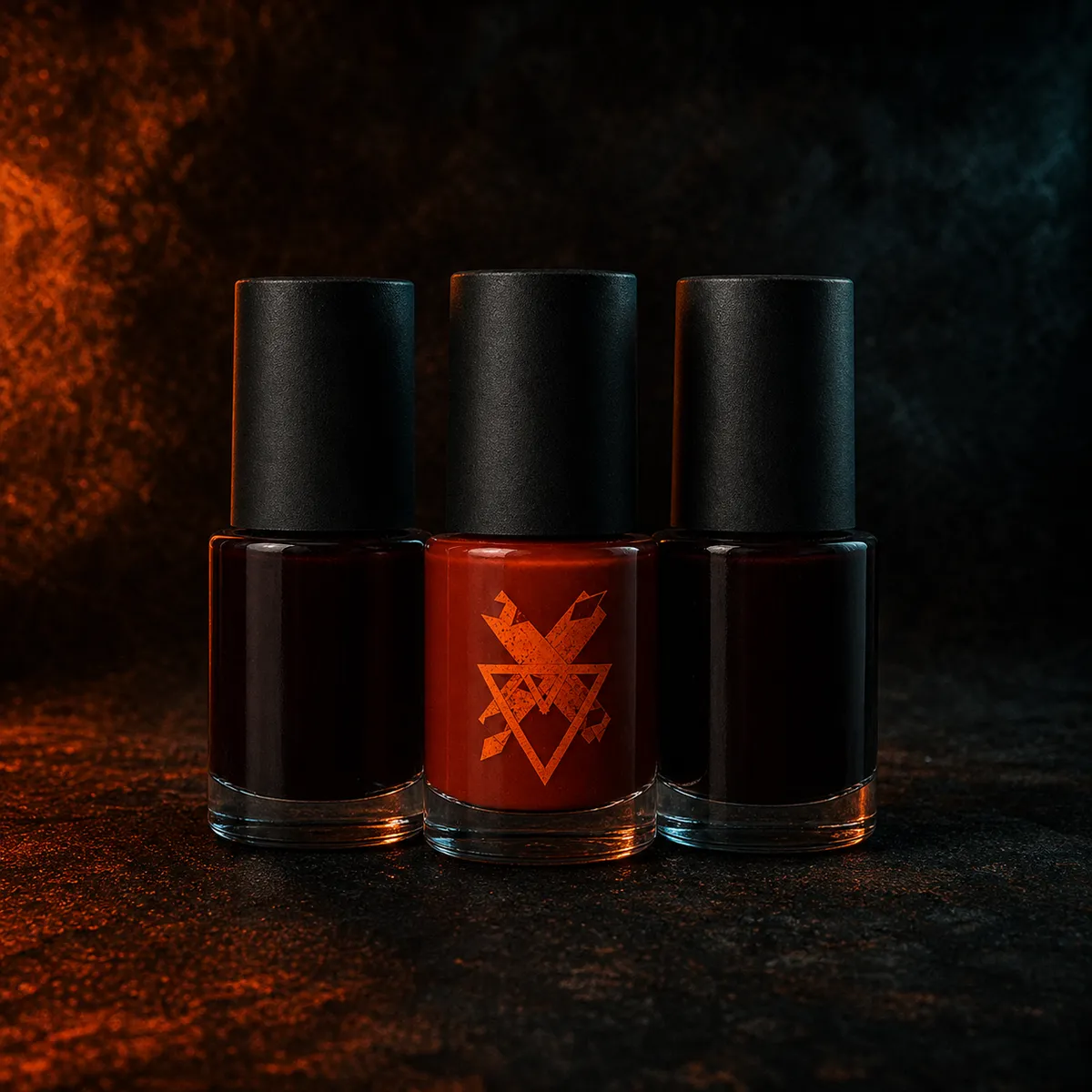 Three matte black nail polish bottles standing together on a dark surface, one filled with deep ember-red polish carrying a distressed ember sigil on its label.